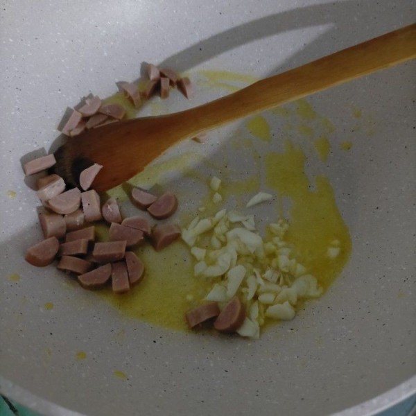 Panaskan margarin. tumis bawang putih dan sosis hingga harum.