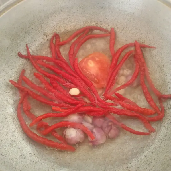 Rebus cabai bawang putih, merah, dan tomat sampai sedikit layu