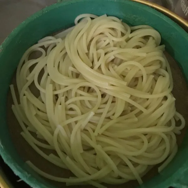 Rebus spagetti dengan air mendidih, tiriskan