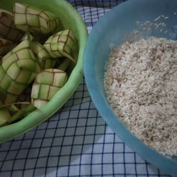 Siapkan sarang ketupat yang telah direndam 1 jam dan dicuci bersih. Siapkan beras ketan yang telah dicuci bersih dan ditiriskan.