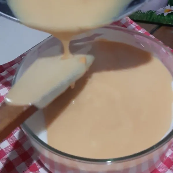 Tuang adonan susu thai tea di atas adonan susu putih, lalu taburi kue marie yang sudah dihancurkan kasar