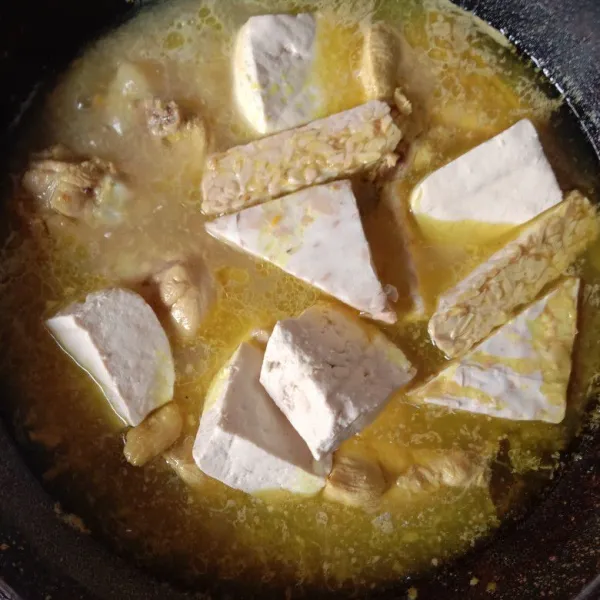 Masukkan santan encer, tahu dan tempe. Bumbui dengan gula dan garam, masak sampai bumbu meresap.