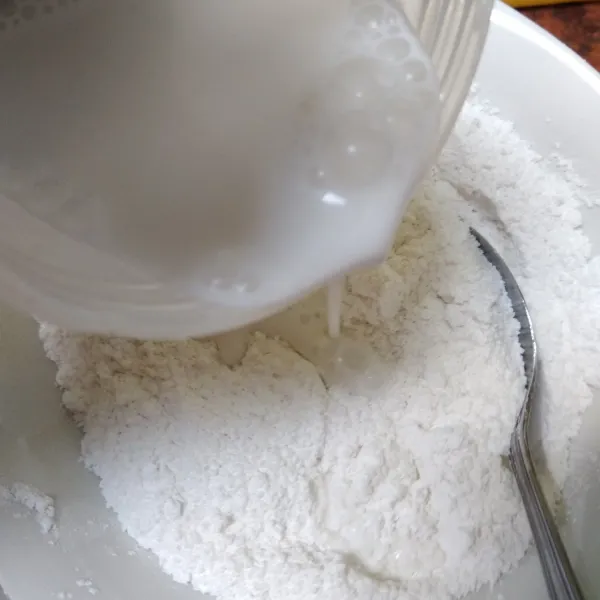 Tuang santan ke dalam adonan tepung.