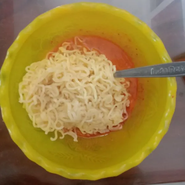 Tiriskan mie yang telah dimasak lalu campur dengan kocokan telur.