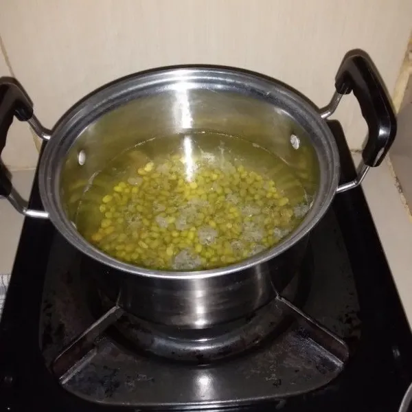 Rebus air hingga mendidih. Masukan kacang hijau rebus selama 5 menit. Matikan api, dan tutupi panci kemudian diamkan selama 30 menit. Nyalakan api kembali, rebus selama 7 menit.