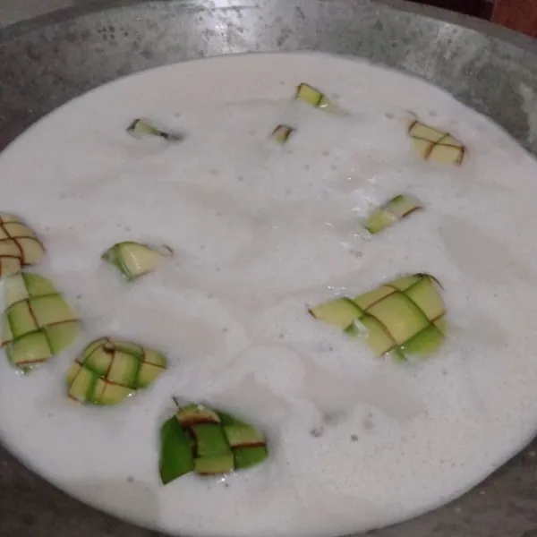 Masukkan ketupatnya, masak hingga santan mendidih sambil diaduk perlahan. Koreksi rasa.