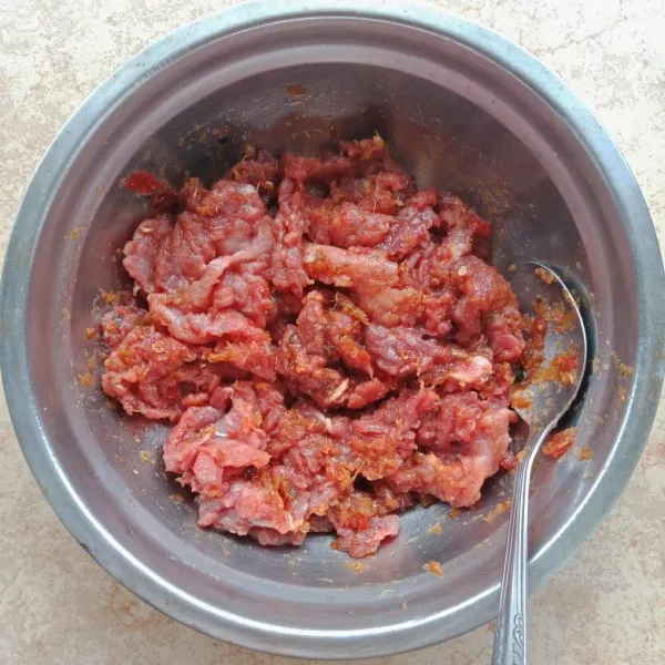 Ambil ½ bagian bumbu, lumuri daging dengan bumbu sampai tercampur rata. Diamkan 15 menit.