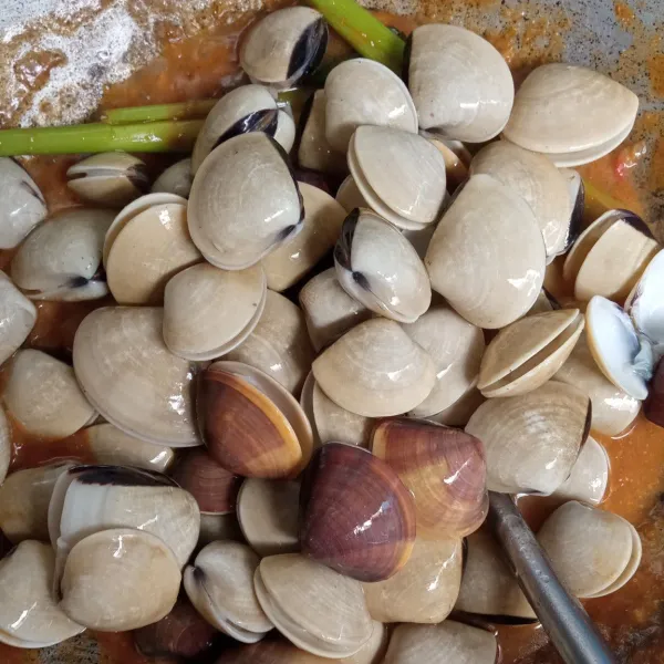 Masukkan bumbu cair, saus tomat, saus tiram, saus cabai, kecap, dan maizena yang sudah dicampur dengan air. Tumis hingga mengental dan masukkan kerang tahu