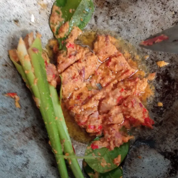 Tumis bumbu halus hingga wangi. Masukkan daun serai, salam, dan daun jeruk hingga layu dengan api sedang. Lalu beri sedikit air