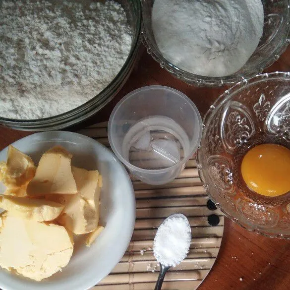 Campurkan bahan-bahan kering (Tepung Terigu, Gula Halus, dan Garam), aduk rata. Kemudian masukkan Margarine atau Butter Dingin, aduk menggunakan tangan hingga berbulir.