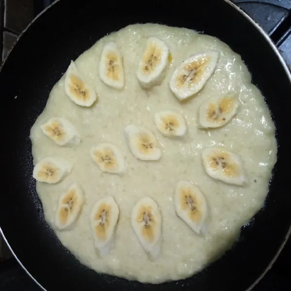 Toping pisang ditata di atas lempeng.