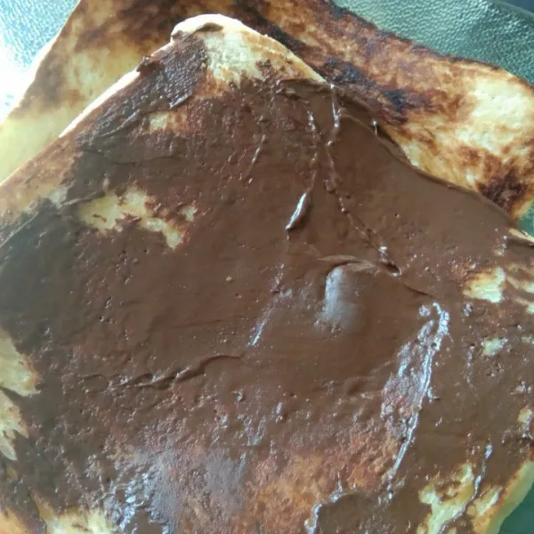 Olesi bagian luar roti dengan selai cokelat, sajikan.