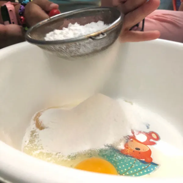 Masukkan 2 butir telur ke wadah dan tambahkan tepung sagu dengan cara diayak lebih dahulu.