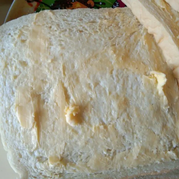 Olesi bagian salah satu sisi luar roti tawar dengan margarin, lakukan hingga roti tawar habis.