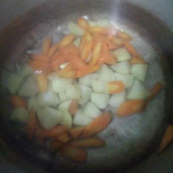 Di wajan terpisah. Panaskan air sampai mendidih. Rebus wortel dan kentang setengah matang.