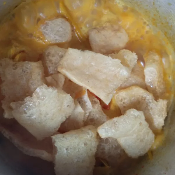 Setelah gulai nangka mendidih dan meresap serta empuk, tambahkan air santan. Lalu aduk pelan agar tidak pecah hingga mendidih. Kemudian matikan apinya, langsung masukkan kerupuk kerecek dan irisan tomat.