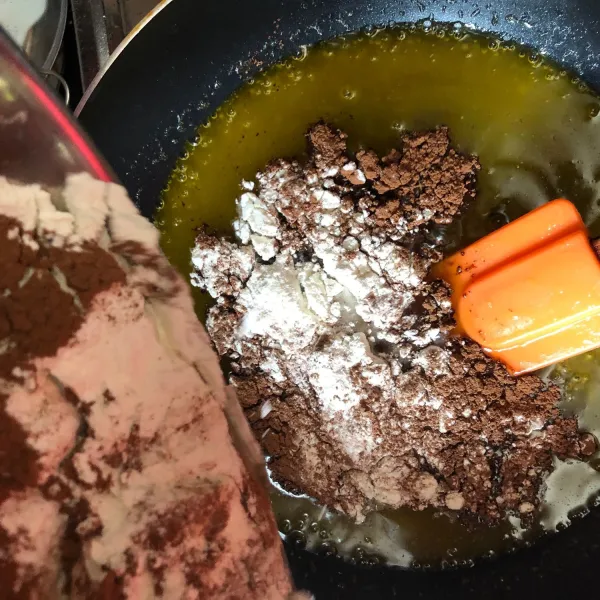 Setelah mendidih, kecilkan api dan masukan campuran tepung dan coklat bubuk. Aduk hingga kalis.