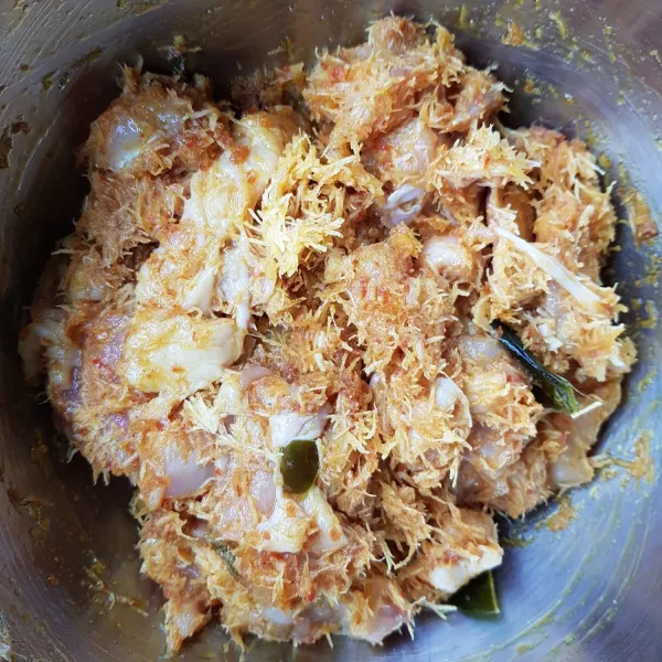 Masukkan kelapa sangrai dan bumbu yang sudah di tumis ke dalam wadah berisi potongan daging ayam. Aduk hingga tercampur rata dan simpan dalam lemari es selama minimal 1 jam.