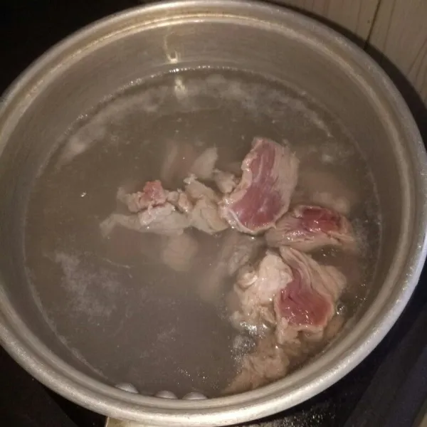 Siapkan panci dan didihkan air. Rebus daging selama 3 menit, tiriskan. Rebus ulang dengan air mendidih sampai setengah empuk, angkat.