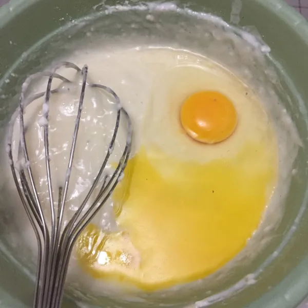 Setelah itu, masukan 1 butir telur dan 1 sdm lelehan margarin dan whisk lagi adonan.