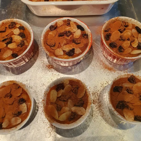 Oles cetakan dengan sedikit mentega lalu isi dengan adonan. Taburi kismis, almond slice dan ayakan kayu manis bubuk diatasnya.