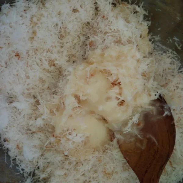 Dalam wadah, masukkan kelapa sangrai, tambahkan kental manis bertahap hingga bisa di bentuk, aduk rata.