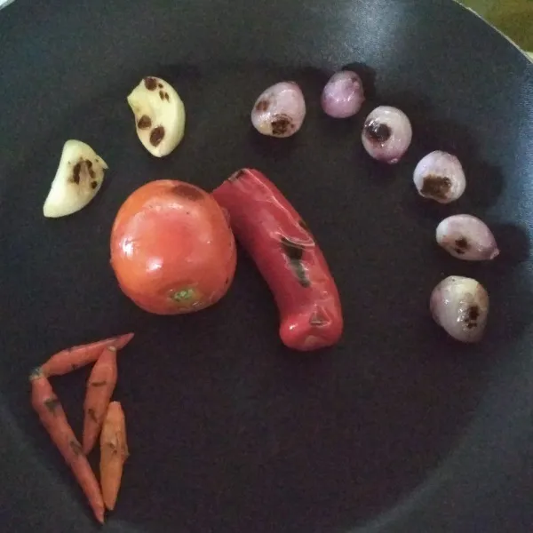 Bakar tomat, cabai, cabak rawit, bawang merah, dan bawang putih hingga semuanya layu.