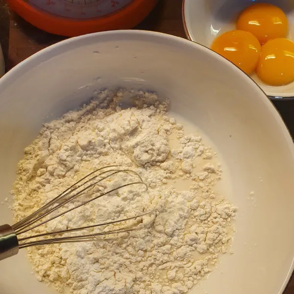 Campurkan tepung, gula pasir dan sisa susu, aduk rata. Masak di atas api kecil. Masukkan karamel, garam, essens vanila. Masak hingga meletup. Matikan api.