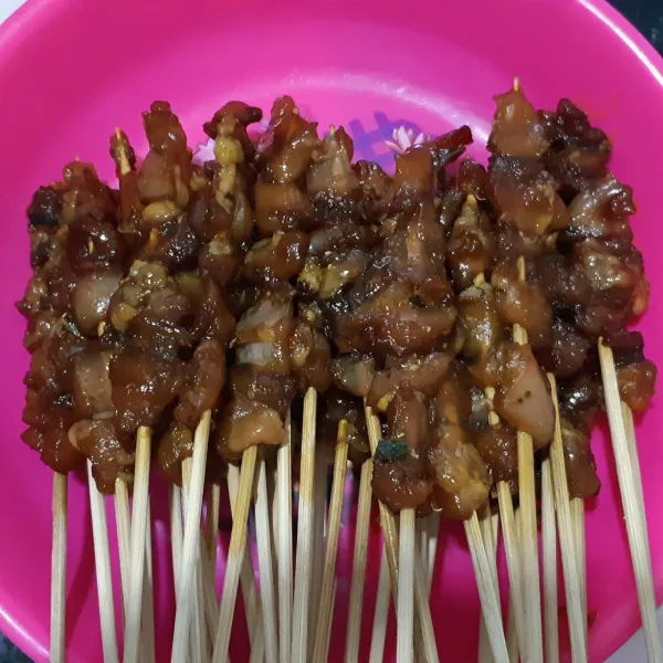 Tusuk daging dengan tusuk sate.