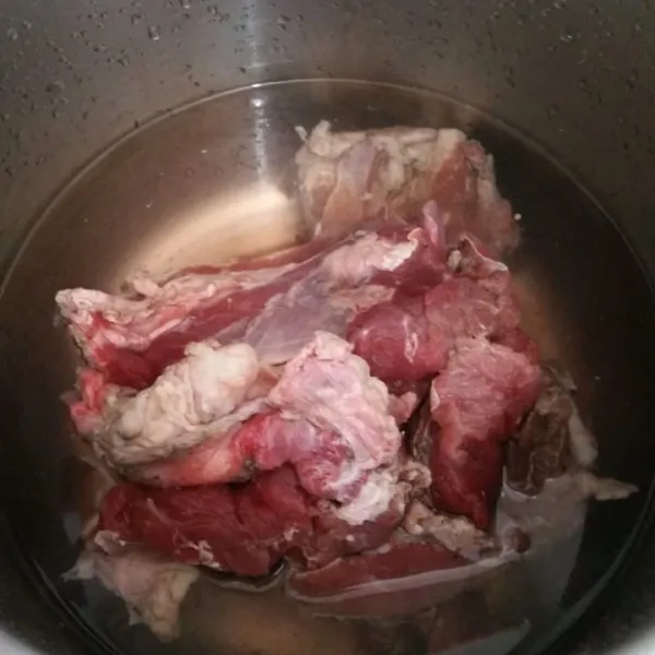 Rebus daging sapi, buang air rebusan pertama, kemudian presto hingga empuk. Saring dan sisihkan air kaldunya.