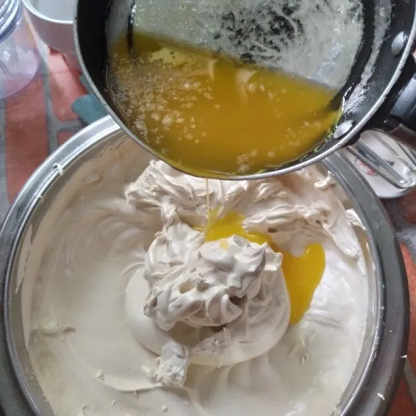 Masukkan margarin yang telah dilelehkan sedikit demi sedikit, aduk dengan spatula. Aduk lipat adonan hingga rata, jangan sampai ada margarin yang tersisa di dasar wadah karena akan membuat bolu menjadi bantat.
