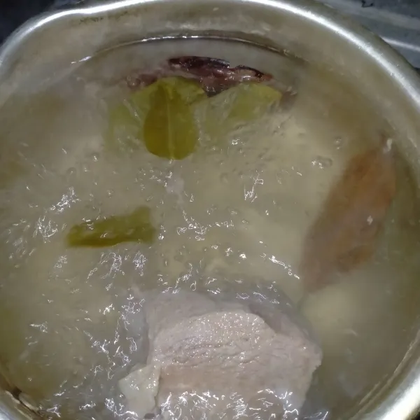 Rebus daging selama 10 menit. Buang airnya. Rebus lagi dengan air baru bersama daun salam dan daun jeruk hingga daging empuk.