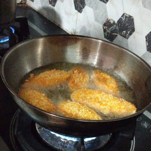 Goreng pisang dalam minyak panas.