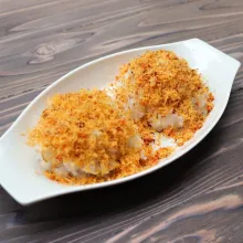 Tumbuk kelapa parut serundeng dan taburi di atas beras ketan yang telah masak.
