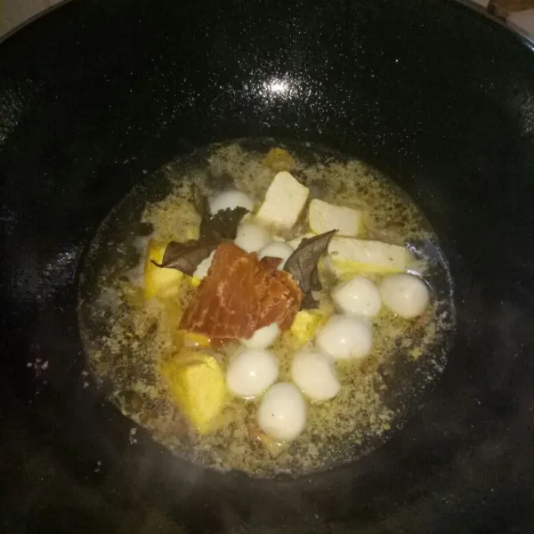 Siapkan pan dan panaskan minyak.Tumis bumbu halus sampai harum,tuang air sampai mendidih.Masukkan telur,tahu,gula merah dan daun salam.Masak sampai gula larut.