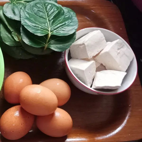 Cuci bersih daun mangkokan kemudian iris halus, potong tahu menjadi 2 bagian.