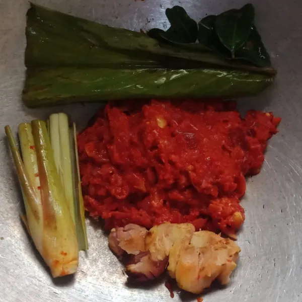 Masukan bumbu halus, daun jeruk, daun kunyit, serai dan laos ke wajan.