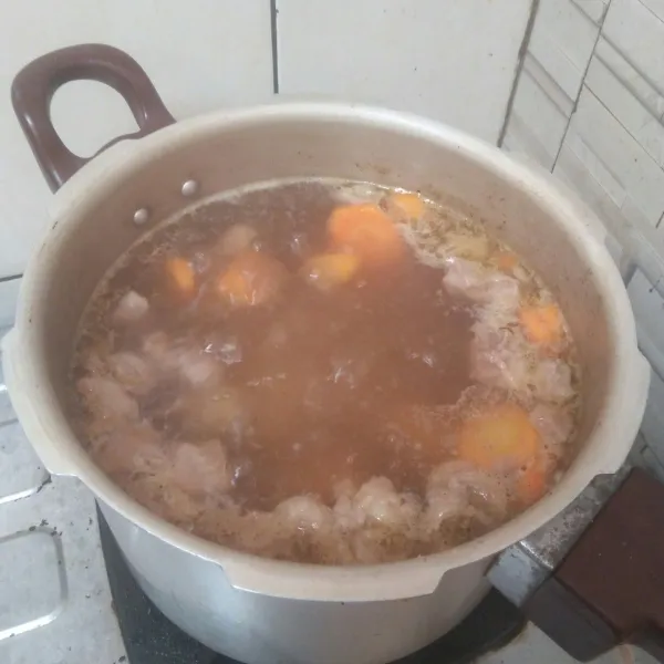 Setelah daging setengah matang potong wortel dan kentang lalu cuci bersih masukan kerebusan daging.