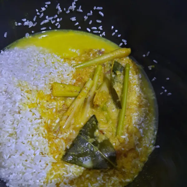 Tuang bumbu santan kuning kedalam beras.