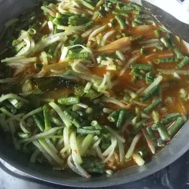 Tuang air, masukan labu siam dan kacang panjang. Aduk rata. Masak hingga mendidih dan sayuran setengah matang.
