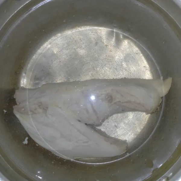 Rebus ayam kampung selama 10 menit. Buang airnya, rebus lagi dengan 2 L air hingga empuk.