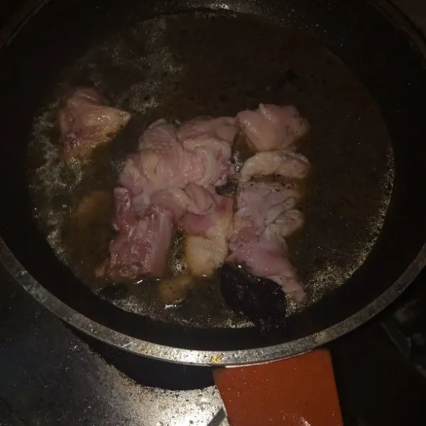 Masukan ayam lalu aduk rata. Masukan air dan kluwek yang sudah dihaluskan dan masak sampai mendidih.