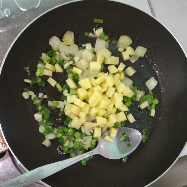 Tambahkan bawang bombay dan kentang. Aduk rata dan masak hingga bawang bombay menjadi lebih bening.