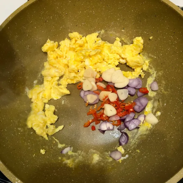 Setelah telur matang, masukkan dan tumis bawang merah, bawang putih, dan  cabai rawit merah. Tumis hingga harum