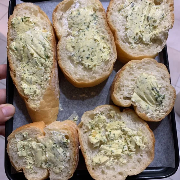 Oleskan garlic butter herbs pada dua sisi potongan roti secara merata