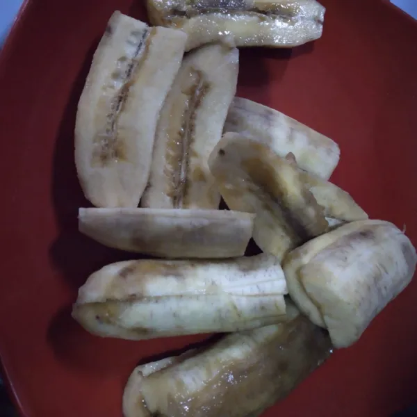Kupas dan potong pisang memanjang sesuai selera.
