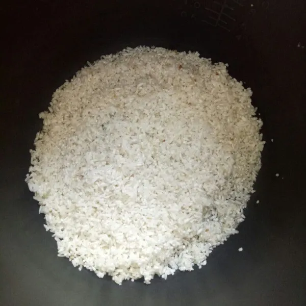 Cuci bersih beras, lalu taruh di panci rice cooker.