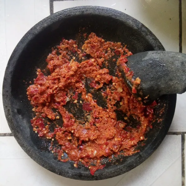 Haluskan bawang merah, bawang putih, cabe keriting, cabe rawit, kemiri, dan terasi.