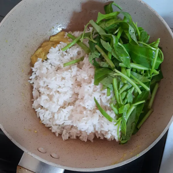 Masukkan nasi. Tambahkan kangkung yang sudah dipetiki daun serta batang mudanya saja.