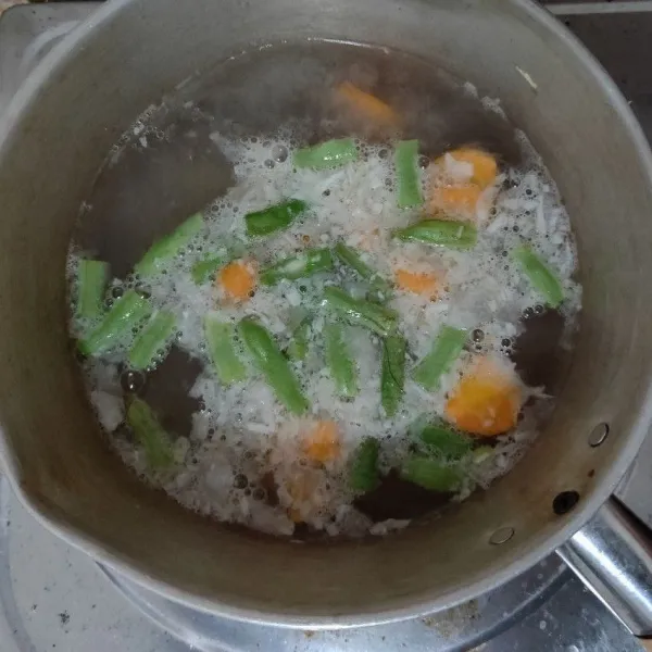 Masukkan wortel, tunggu beberapa saat. Lalu masukkan buncis, kentang, gula, garam, dan kaldu bubuk. Masak hingga wortel dan buncis lunak